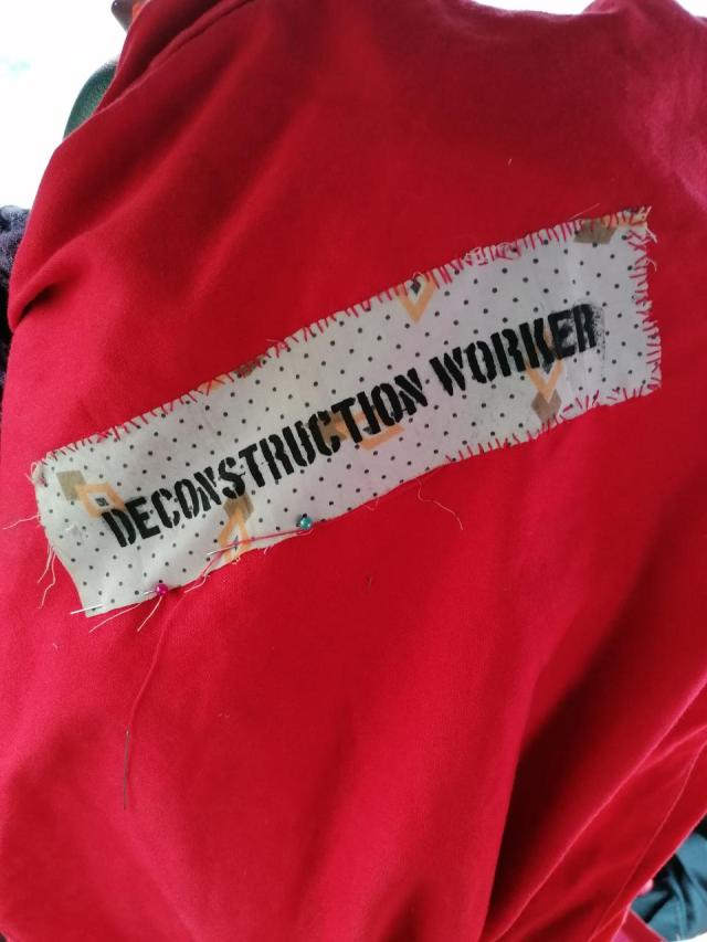 picture of a red jacket which has a label saying "deconstruction worker"