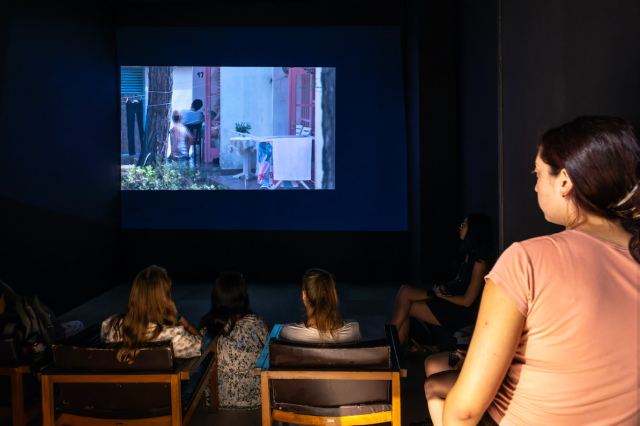 A crowd watching a film inside a dark room