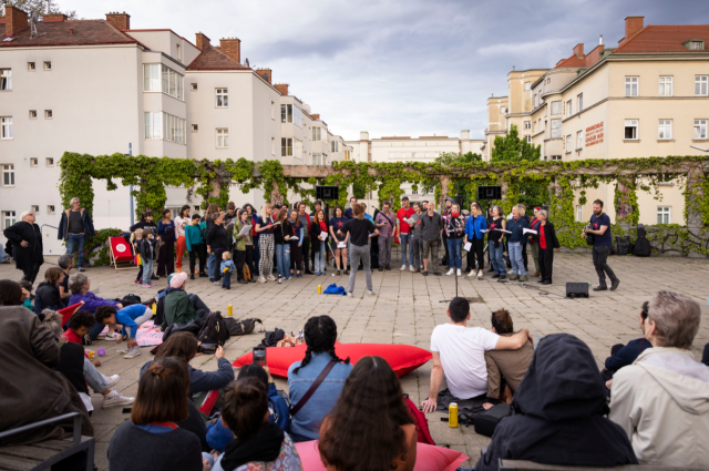 A group of people assisting a group performance on the street.