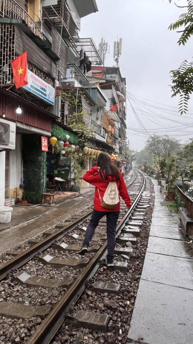 Die Autorin geht auf eine Straße mit Zug Schienen in Hanoi.